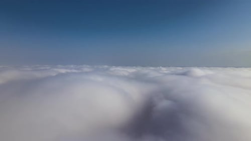 Aerial View From Airplane Window at High Altitude of Earth Covered with White Puffy Cumulus Clouds