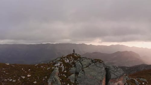 Flying over a person on a mountain ledge