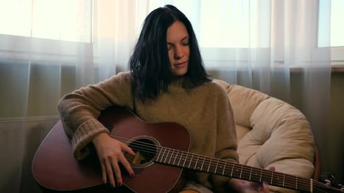 Woman Plays Acoustic Guitar Indoors Daytime