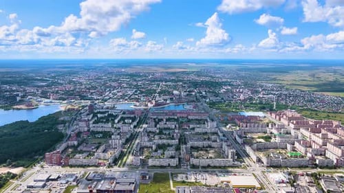 Drone suburban panorama. River, park and residential buildings under cloudy sky