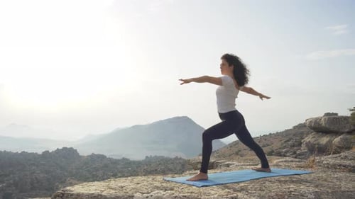 Woman Practices Yoga Outdoors in Mountain Landscape