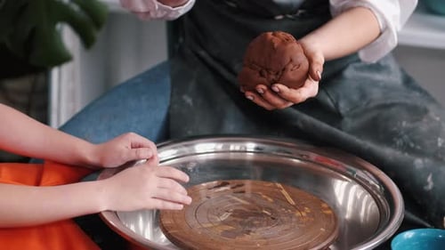 Closeup of Woman and Little Girl Working in Pottery Workshop