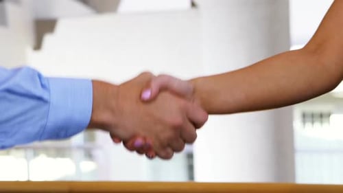 Executives shaking hands in conference centre
