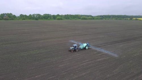 Powerful Agricultural Tractor Apply Mineral and Nitrogen Fertilizer on Ground at Field
