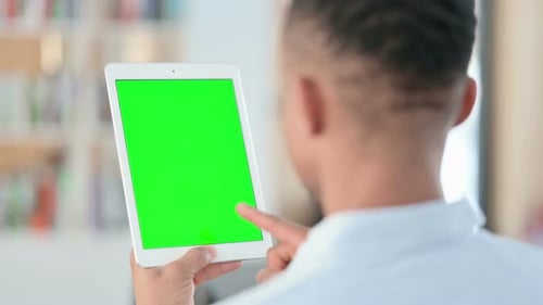 African Man Using Tablet with Green Chroma Key Screen Rear View