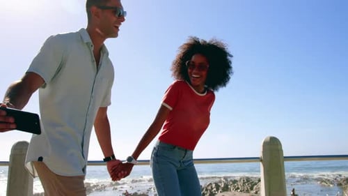 Couple taking selfie while walking on beach promenade 4k