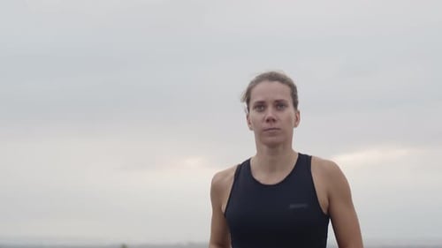 Caucasian female athlete running, front view. Woman with her hair in a ponytail runs workout