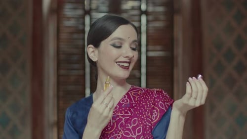 Hindu Woman Opening Bottle and Applying Perfume