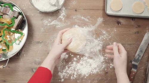 Hands Making Christmas Cookies with Cookie Cutters
