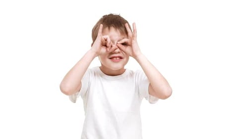Boy Pretends with Hand Binoculars on White Background