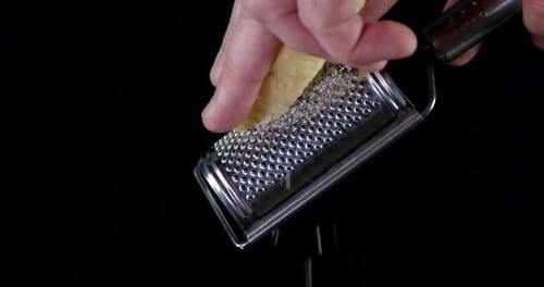 A Piece of Parmesan Cheese Shredded on a Grater.