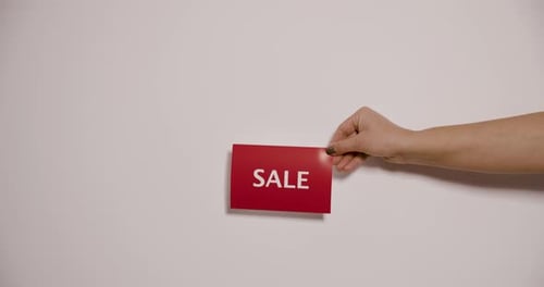 Hand Holding a Sale Sign on White Background