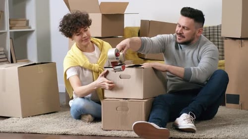 Caja de paquete de 30 años mujer caucásica ayudando a su esposo