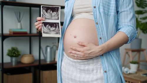 Pregnant Woman Holding Ultrasound Picture of Baby