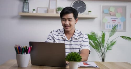 Portrait of Happy asian businessman with laptop computer working at home office