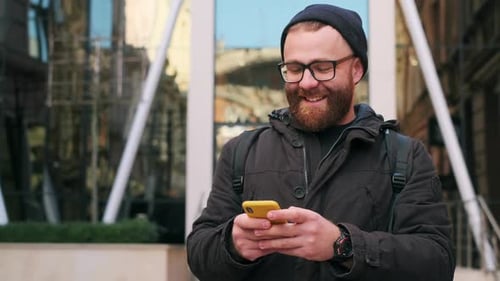 Bearded Man Using Smartphone in Urban Setting