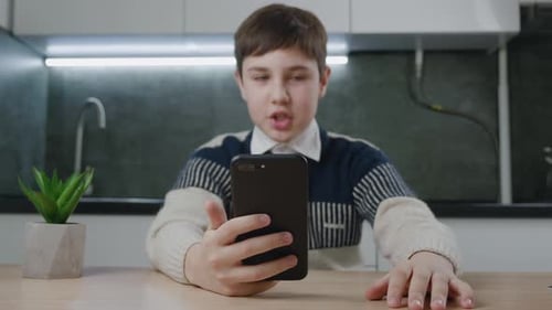 Teen Boy Video Calling on Smartphone Indoors