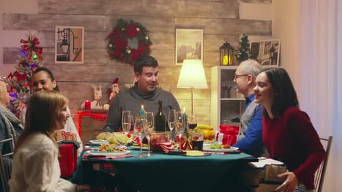 Family Exchanging Gifts at Christmas Dinner Celebration