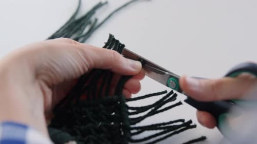 Hands Carefully Trim Macrame Fringe with Scissors