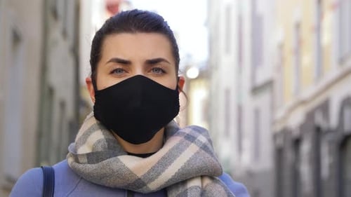 Woman in Face Mask with Stop Sign in City
