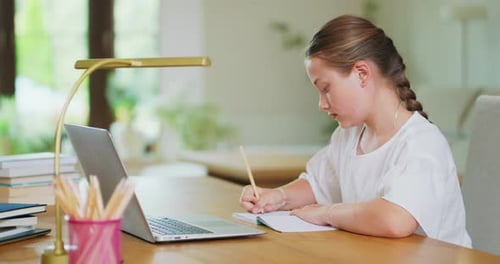 Child Studies at Desk with Laptop and Pencil
