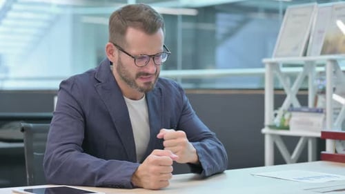 Middle Aged Businessman Feeling Angry While Sitting in Office