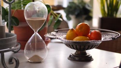 Elegant Hourglass and Fruit Display on Tabletop