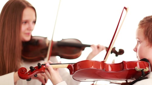 Boy and Girl Playing Violin in Indoor Setting
