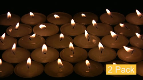 Glowing Candle Flames Flickering in the Darkness