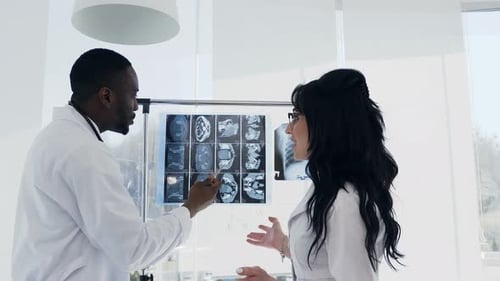 Doctors Reviewing Medical Scans and Shaking Hands