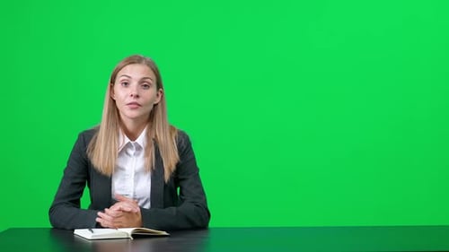 Une intervieweuse est assise à une table et parle à un interlocuteur lors d'un entretien à la première personne