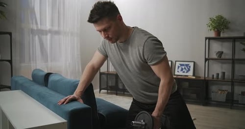Man Doing Dumbbell Rows at Home