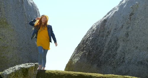 Woman walking on a rock at beach 4k