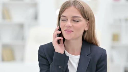 Woman Smiling During Pleasant Phone Call in Office