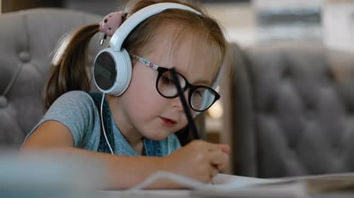 Diligent Girl Studying at Home With Headphones