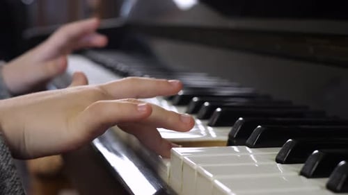 Child's Hands Playing Piano Keys Close Up