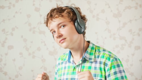 Young Man Dancing with Headphones Indoors
