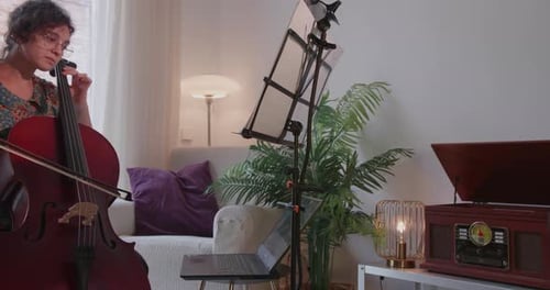 Woman Plays Cello in Brightly Lit Living Room