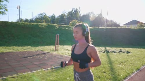 Woman Running at Stadium Listening to Music