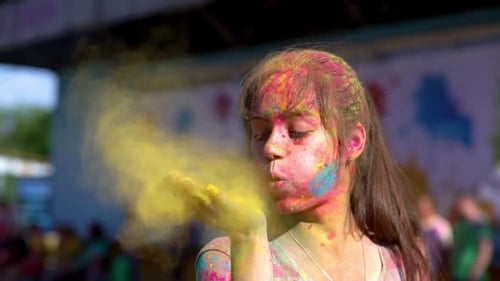 Young Woman Blowing Color Powder During Holi Festival