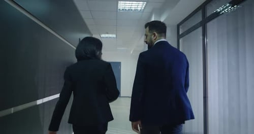 Business Professionals Walk Down Modern Office Hallway