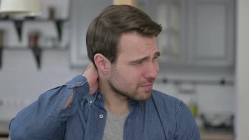 Young Adult Man Rubbing Sore Neck