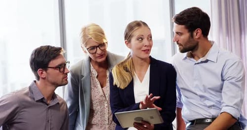 Colleagues Meeting in a Corporate Workplace Discussing Tablet
