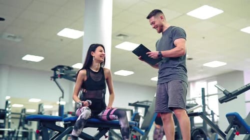 Personal trainer working with his client in gym. Personal fitness instructor.