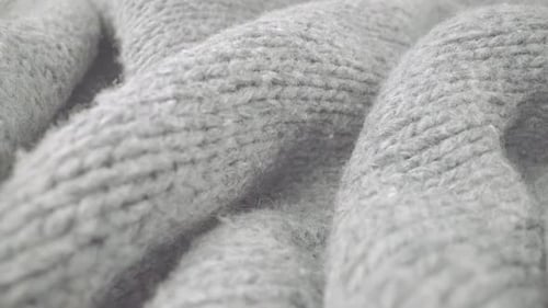 Extreme detail view of sheep wool cloth texture flowing in macro dolly shot.
