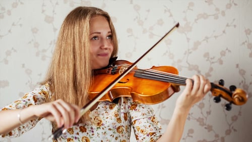 Woman Plays Violin Indoors in Close Up