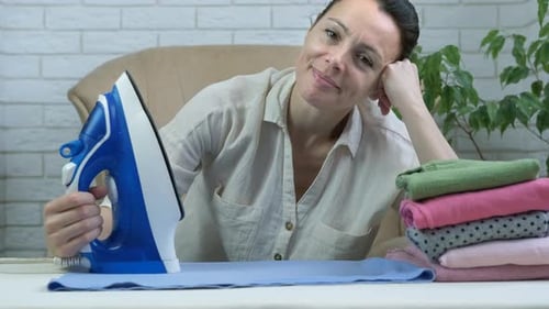 Woman Ironing Laundry at Home with Contented Expression