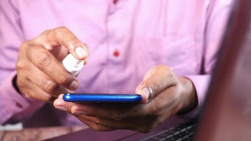 Spraying Sanitizer on Smartphone for Hygiene