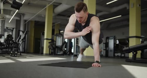 Young Muscular Athlete Works Out in a Modern Gym Making Push Ups Exercises