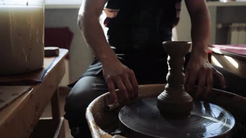 Le potier découpe le produit fini du vase dans la roue du potier